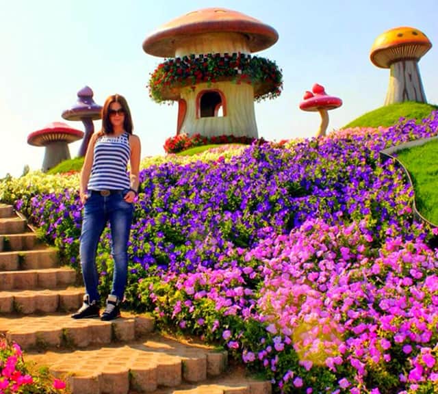 Mushroom Houses and visitor's photograph at the Dubai Miracle Garden.
